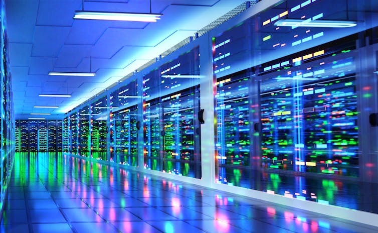 A photo of a modern server room and corridor in a data center with supercomputer racks, neon lights and air conditioners.